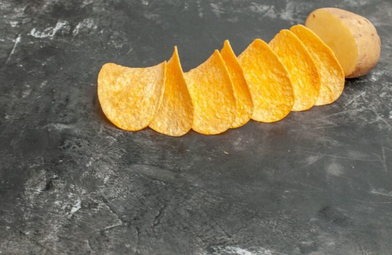 Comment sont fabriquées les chips industrielles organisation du process de production Chips alignées à côté d'une pomme de terre